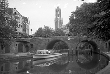 810954 Gezicht over de Oudegracht te Utrecht op de Domtoren; op de voorgrond de rondvaartboot Jan van den Doem onder de ...